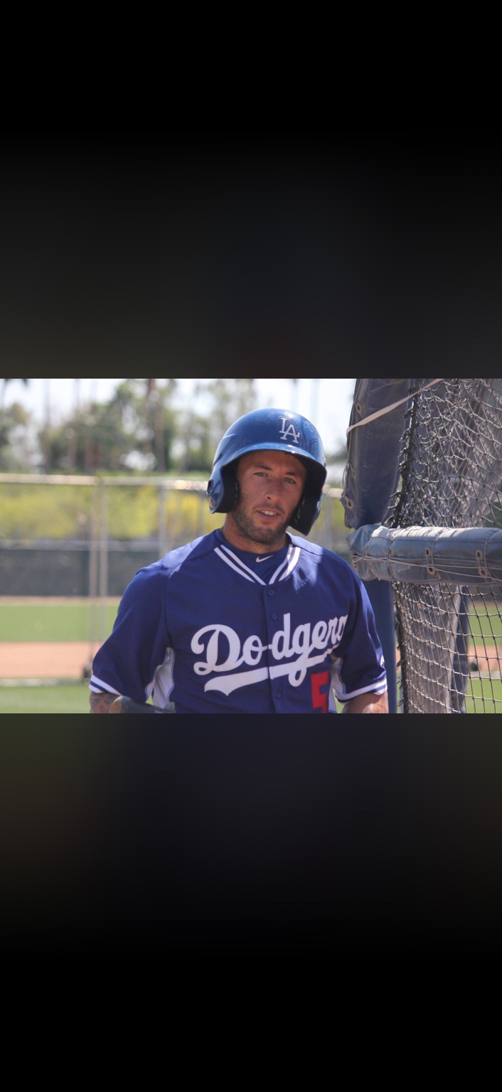 Robbie in a Dodgers uniform beside the batting cage
